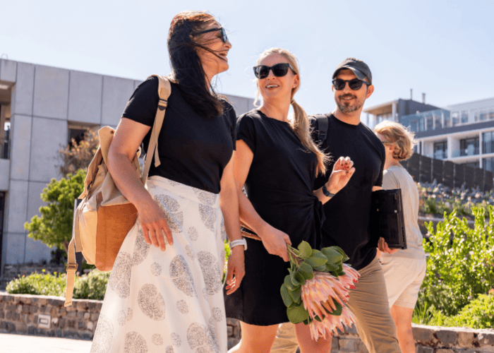 Team photo of three colleagues walking in a row holding Protea flowers